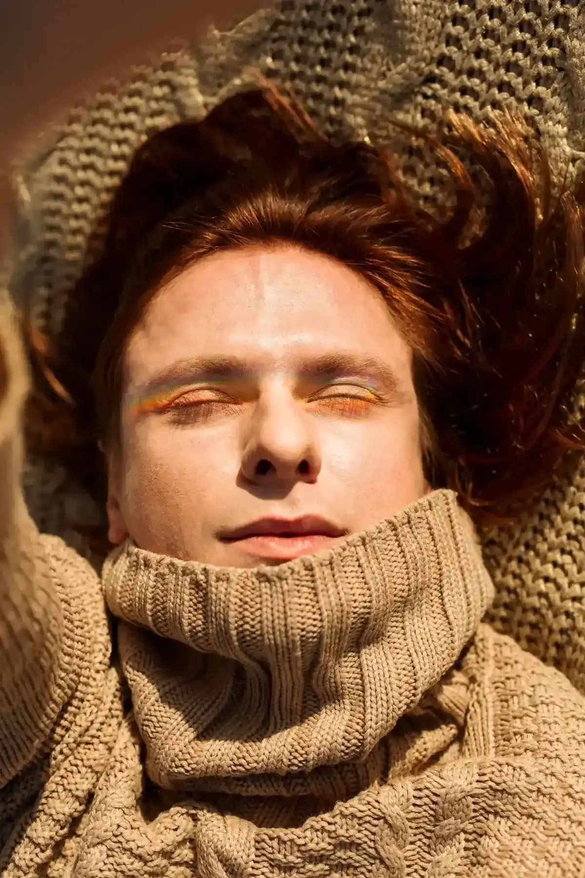 A person resting with eyes closed in warm sunlight